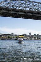 False Creek Ferry passes under a bridge, Vancouver, BC