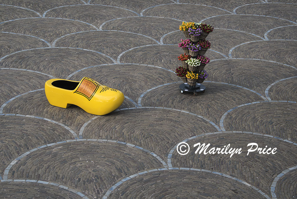 Oversized Dutch wooden shoe with stand of wooden tulips on a patterned patio, Keukenhof Gardens, Netherlands