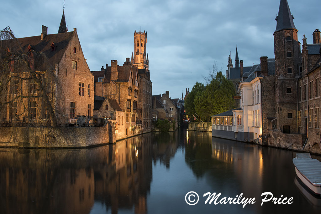 Buildings (including The Belfry) reflected in a canal at twilight, Bruges, Belgium