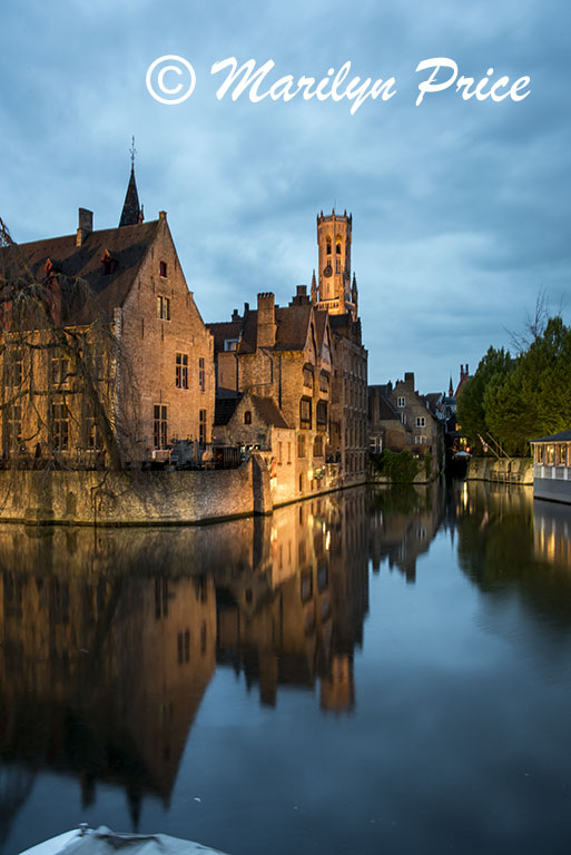 Buildings (including The Belfry) reflected in a canal at twilight, Bruges, Belgium