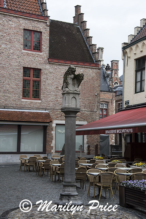 Small courtyard with a statue and an outdoor restaurant, Bruges, Belgium