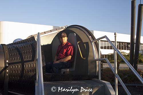 Carl sits in a mockup of a Gemini capsule, Rocket Garden, Kennedy Space Center, FL