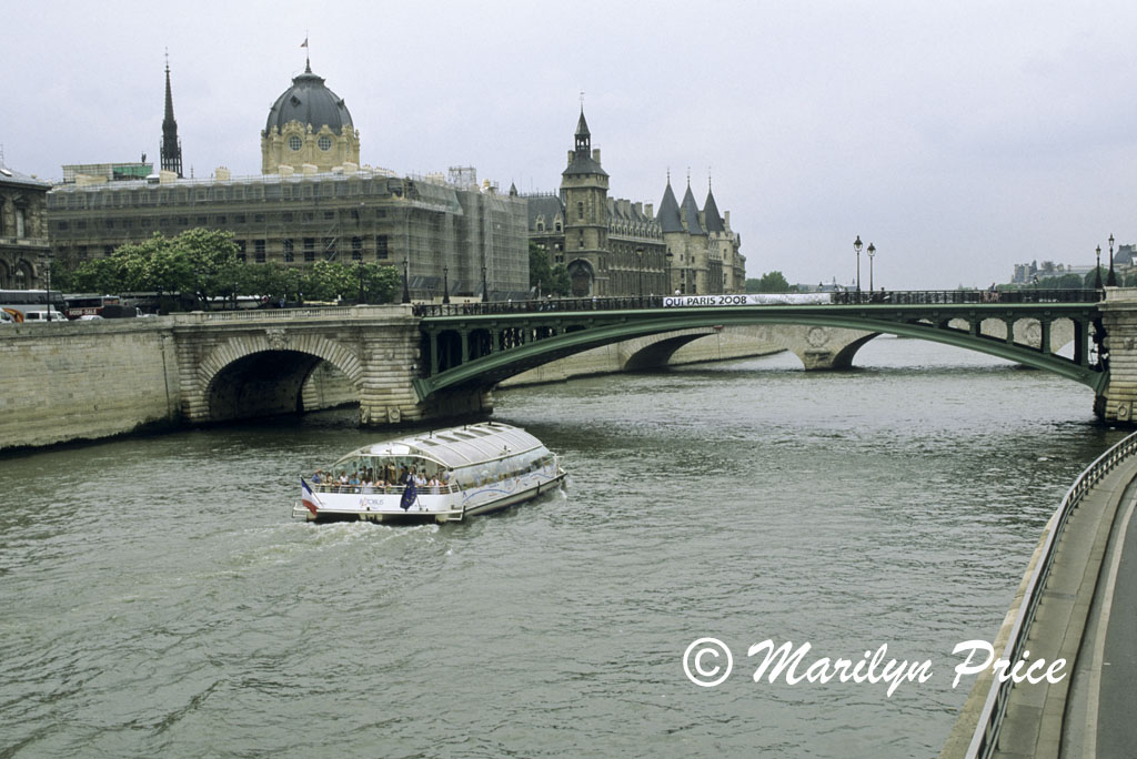 A tour boat on the Seine passes near the Conciergerie, Paris, France