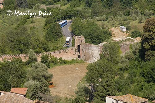 Tour buses approach the city walls, Siena, Tuscany, Italy