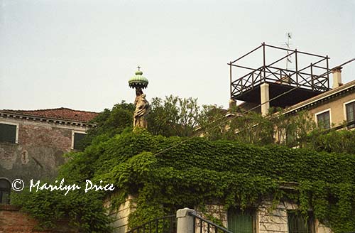 Statue atop a wall around a private garden, Venice, Italy