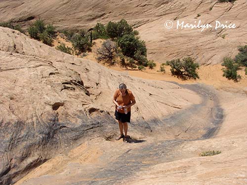 Jenny scouts one of the obstacles on Hell's Revenge, near Moab, UT