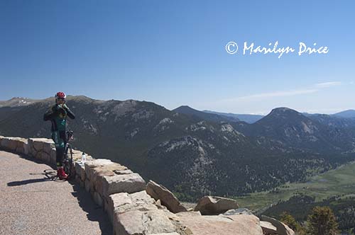 A bicyclists takes a break at Rainbow Curve, Rocky Mountain National Park, CO