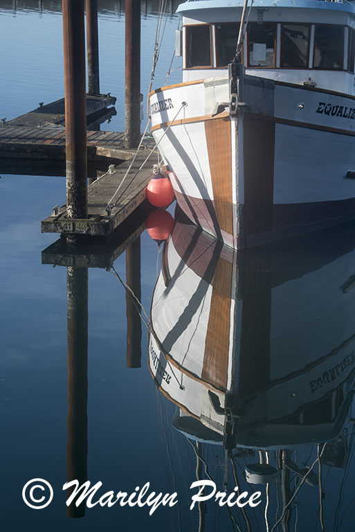 Reflections of a fishing boat, Yaquina Bay harbor, Newport, OR