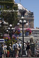 A crowd watches a street performer on the dock in front of the Empress Hotel, Victoria, BC